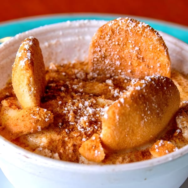 Close-up of Adam's Rib Co. banana pudding with vanilla wafers, cinnamon, and powdered sugar.