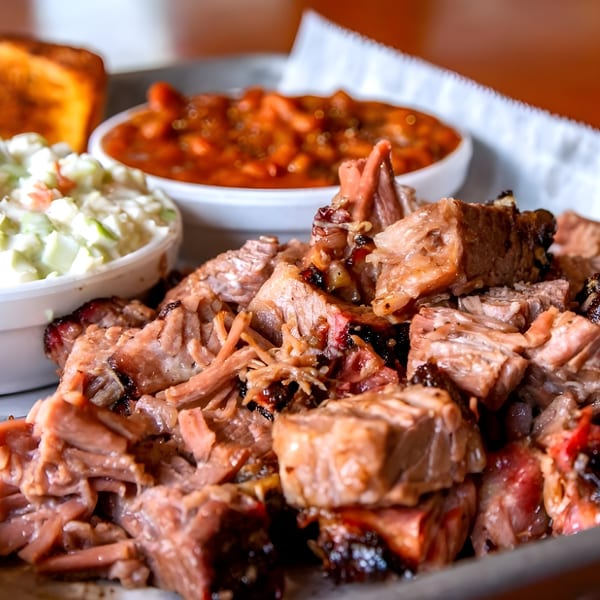 Adam's Rib Co. BBQ plate with chopped brisket, baked beans, coleslaw, and toast.